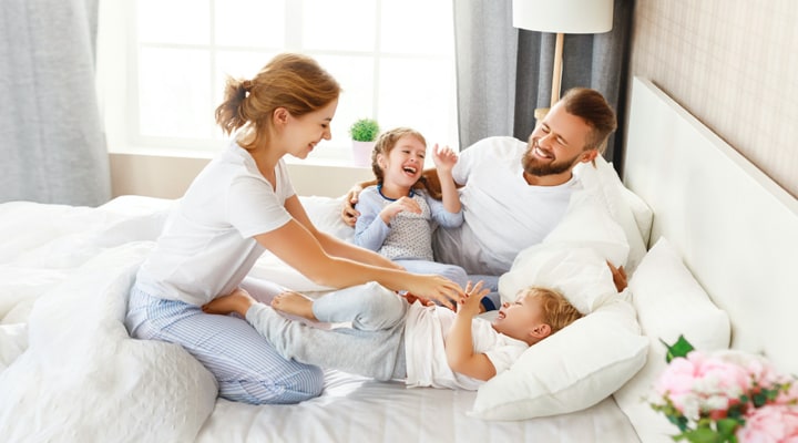 Woman in bed with her partner and children