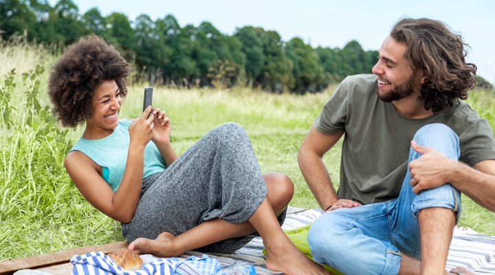 A woman and her partner on a picnic blanket.